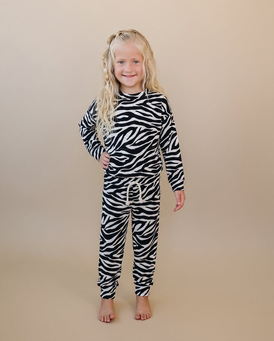 Little one wearing the Zebra Jogger Set with bold black and white animal print
