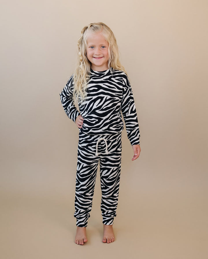 Little one wearing the Zebra Jogger Set with bold black and white animal print